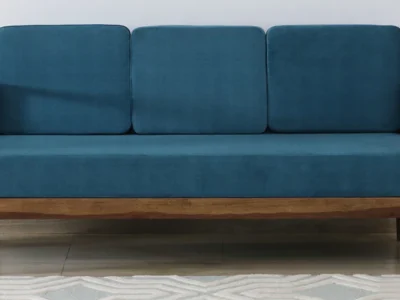 Wooden three seater sofa with side armrests and soft cushions