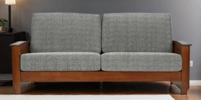 Wooden sofa with three cushions and neutral colored fabric upholstery