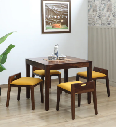 Crestwood Sheesham Wood 4 Seater Dining Set by Sarve Furniture.​ Front view of Crestwood dining table with four chairs in Sheesham wood finish.​ Side angle of Crestwood 4 Seater Dining Set showcasing natural wood grain.​ Close-up of Crestwood dining chair detailing and craftsmanship.​ Crestwood dining set in a modern dining room setting by Sarve Furniture.