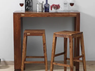 Emberstone Sheesham wood bar table set with two stools by Sarve Furniture.​ Front view of Emberstone bar table set showcasing natural wood grain.​ Side angle of Emberstone bar stools highlighting ergonomic design.​ Close-up of Emberstone bar table surface with smooth finish.​ Emberstone bar set in a modern kitchen setting by Sarve Furniture.​ Top-down view of Emberstone bar table set displaying compact design.​ Macy's Emberstone Sheesham wood bar stools with footrests and sturdy legs.​ Detailed view of Emberstone bar table corner craftsmanship.​ Emberstone bar table set with stools tucked under for space-saving.​ Emberstone bar set by Sarve Furniture in a cozy dining nook.