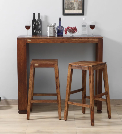 Emberstone Sheesham wood bar table set with two stools by Sarve Furniture.​ Front view of Emberstone bar table set showcasing natural wood grain.​ Side angle of Emberstone bar stools highlighting ergonomic design.​ Close-up of Emberstone bar table surface with smooth finish.​ Emberstone bar set in a modern kitchen setting by Sarve Furniture.​ Top-down view of Emberstone bar table set displaying compact design.​ Macy's Emberstone Sheesham wood bar stools with footrests and sturdy legs.​ Detailed view of Emberstone bar table corner craftsmanship.​ Emberstone bar table set with stools tucked under for space-saving.​ Emberstone bar set by Sarve Furniture in a cozy dining nook.