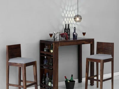 Monarch bar table set with 2 grey cushioned stools – Sarve Furniture Monarch bar table and stools in grey and wooden finish – front view Close-up of grey cushioned bar stools from Monarch set Monarch bar table with sleek top and soft padded stools